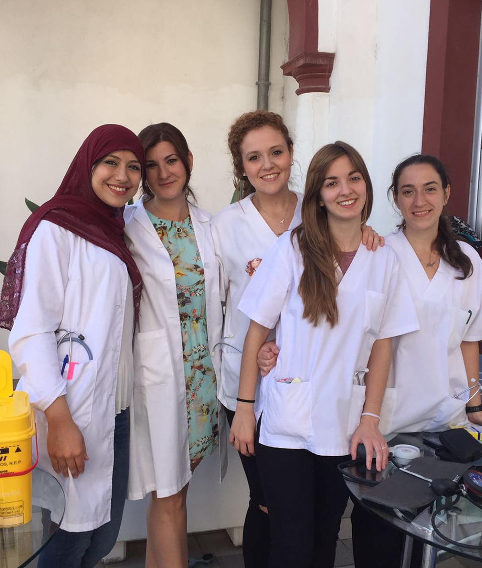 Grupos de mujeres de la facultad de Ciencias de la Salud de Ceuta posando detras de unas mesas