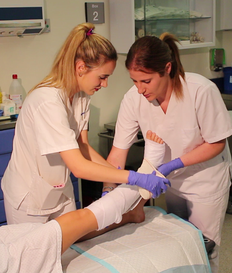 Enfermeras realizando un vendaje a un paciente en una pierna