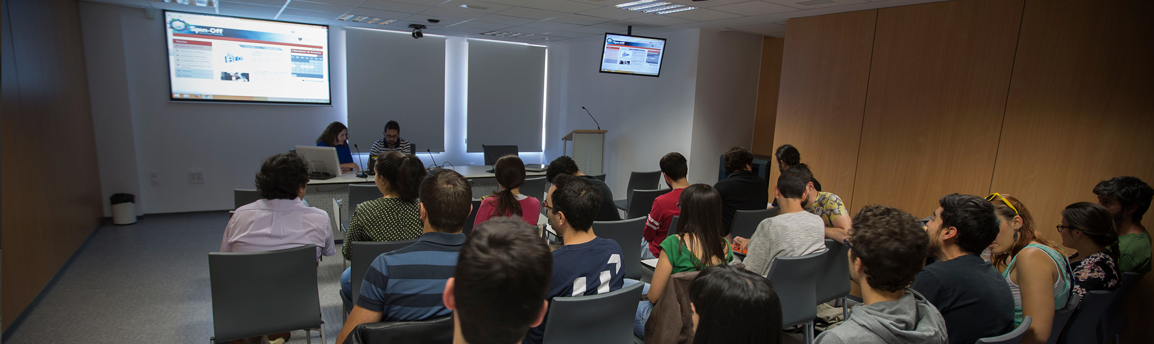 En la imagen, un grupo de personas asisten a una exposición en una sala auxiliar de conferencias en el Centro de Transferencia Tecnológica